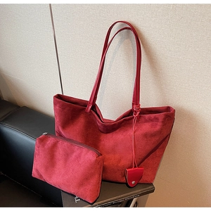 Detail view of large burgundy suede tote bag and matching zipper pouch for women