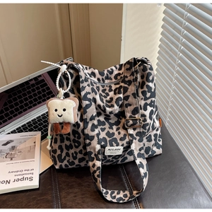 Leopard print canvas tote bag with adjustable strap and cute bread plush charm detail