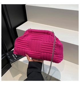 Detailed view of magenta woven clutch bag with silver chain and textured knit finish