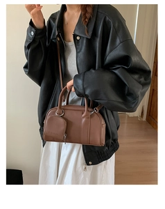 Brown leather Boston bag detail featuring a mini zipper pouch and adjustable strap