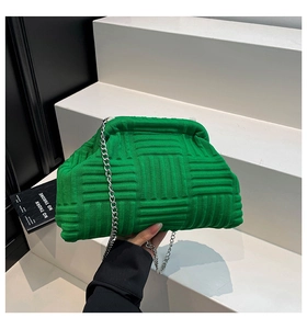Detailed macro view of bright green knitted shell bag with textured weave and silver chain