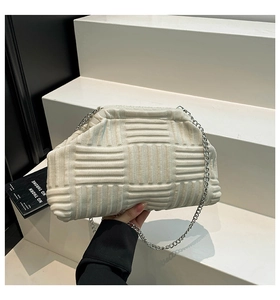 Detail shot of cream-white woven cloud bag with textured fabric and silver chain strap