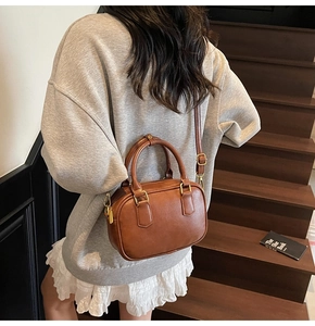 Detailed back view of a vintage brown mini Boston bag with gold-tone hardware
