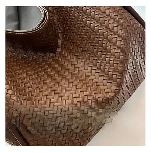 Macro detail of brown leather woven texture on large tote bag with high-end craftsmanship
