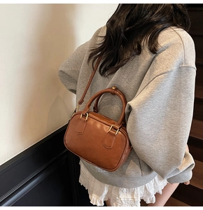 Detail of a brown vintage Boston bag showing its size and fit on a person's shoulder