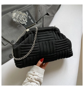 Detail of black woven cloud bag with silver chain strap and soft knitted texture