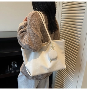 Detail of white large tote bag with textured faux leather and matching round coin purse