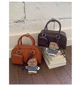 Detail of vintage square handbags in caramel and chocolate with teddy bear charms