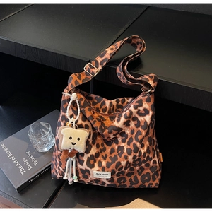 Detail of leopard print tote bag featuring a cute toast plush charm and tassel accent