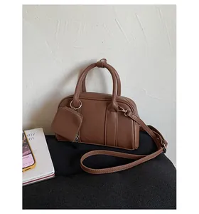 Detailed close-up of dark brown vintage mini Boston bag with matching coin pouch accessory