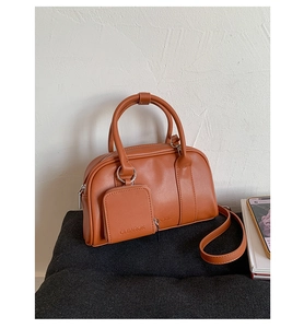 Detailed view of the CLEAROK embossed logo on a vintage caramel brown leather Boston bag