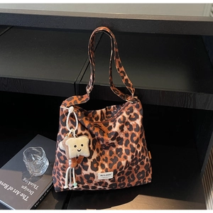 Macro detail of leopard print hobo bag featuring a cute plush toast charm and adjustable strap