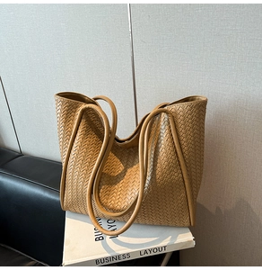 Close-up of camel leather woven tote bag showing detailed geometric texture and stitching
