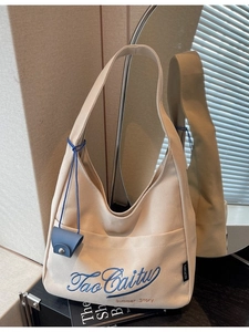 Minimalist beige canvas tote bag with blue Tao Caitu embroidery and small hanging pouch