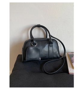 Detail of black matte leather Boston bag with CLEAROK branding and matching coin purse