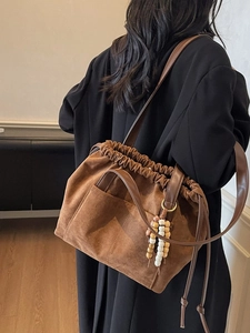 Vintage brown faux suede bucket bag with leather straps and bead charm detail