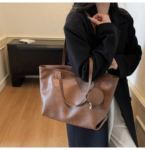 Detail of a brown large capacity tote bag with soft PU leather texture and a coin purse