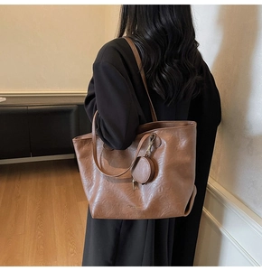 Detailed back view of a brown vintage PU leather tote bag with a mini coin purse pendant