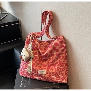 Detail of pink leopard canvas tote bag with MULAIDI leather tag and plush toast charm