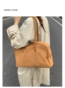 Gros plan d'un grand sac bandoulière en daim fauve avec doubles anses et texture douce