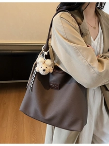 Grand sac cabas marron en similicuir avec charm chiot en peluche porté par un mannequin