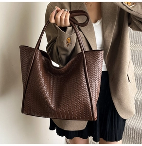 Detail of the woven leather texture on a dark brown large-capacity tote bag