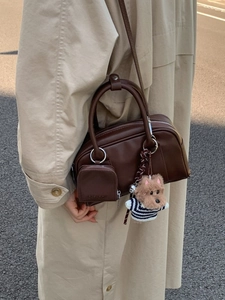 Deep brown leather bowling handbag for women with cute puppy charm and mini pouch accessory