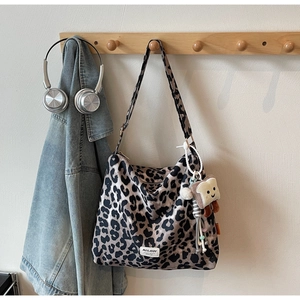 Detailed view of leopard print canvas tote bag with a cute toast plush keychain accessory