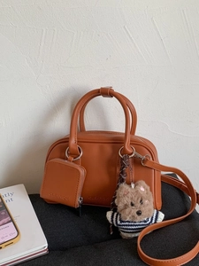Caramel faux leather handbag with adjustable strap and cute plush puppy charm accessory