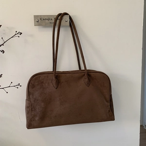 Détail du grand sac cabas en daim marron foncé avec fines bandoulières et fini mat
