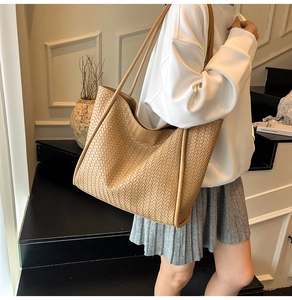 Detail of a large khaki woven tote bag showing premium synthetic leather texture