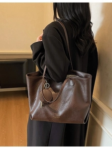 Deep brown minimalist faux leather tote bag with shoulder straps and small round pouch