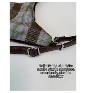 Detail of adjustable leather strap with silver buckle on a plaid tweed tote bag