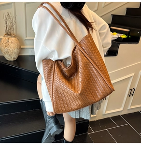 Deep brown woven tote bag detail showing the intricate intrecciato texture and large capacity