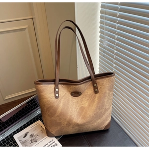 Detailed close-up of a large vintage tote bag with retro textures in a cozy office setting