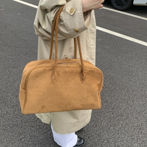 Détail d'un sac cabas en daim camel avec fermeture éclair et bandoulières solides