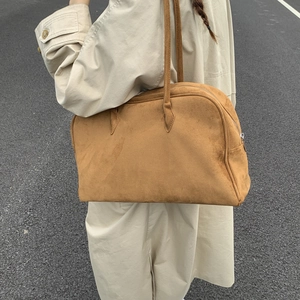 Vue détaillée d'un grand sac cabas en daim marron montrant sa texture douce et sa taille
