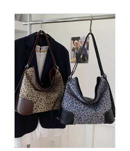 Detailed close-up of leopard print canvas and leather patchwork hobo tote bags