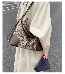 Detailed view of leopard print tote bag with brown leather corners and adjustable strap