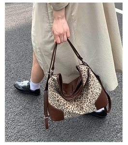 Macro detail of large leopard print tote bag with brown leather patchwork and stitching