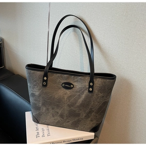 Close-up of gray marbled leather tote bag featuring a metallic M.Duo brand logo plate