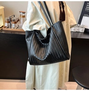 Detail of black woven leather tote bag showing large capacity and textured finish