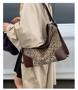 Close-up of leopard print tote bag with reinforced brown leather base and corners