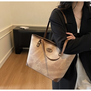 Close-up of textured marble pattern tote bag with leather straps on a model