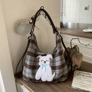 Detail of vintage plaid wool tote bag with cute dog patch in warm home setting