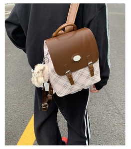 Detailed view of women's vintage plaid backpack with leather flap and plush ball charm