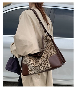 Outdoor lifestyle view of large leopard print hobo bag with brown leather stitching