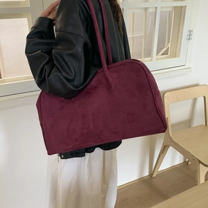 Vue latérale du grand sac cabas en daim bordeaux porté avec une tenue minimaliste