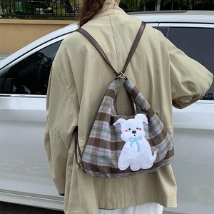 Detail of plaid wool backpack featuring a cute puppy embroidery patch and leather straps