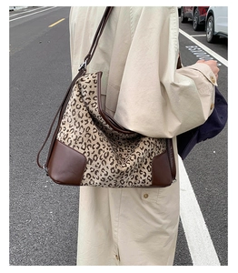 Detail of large leopard print hobo bag with brown leather trim and adjustable strap